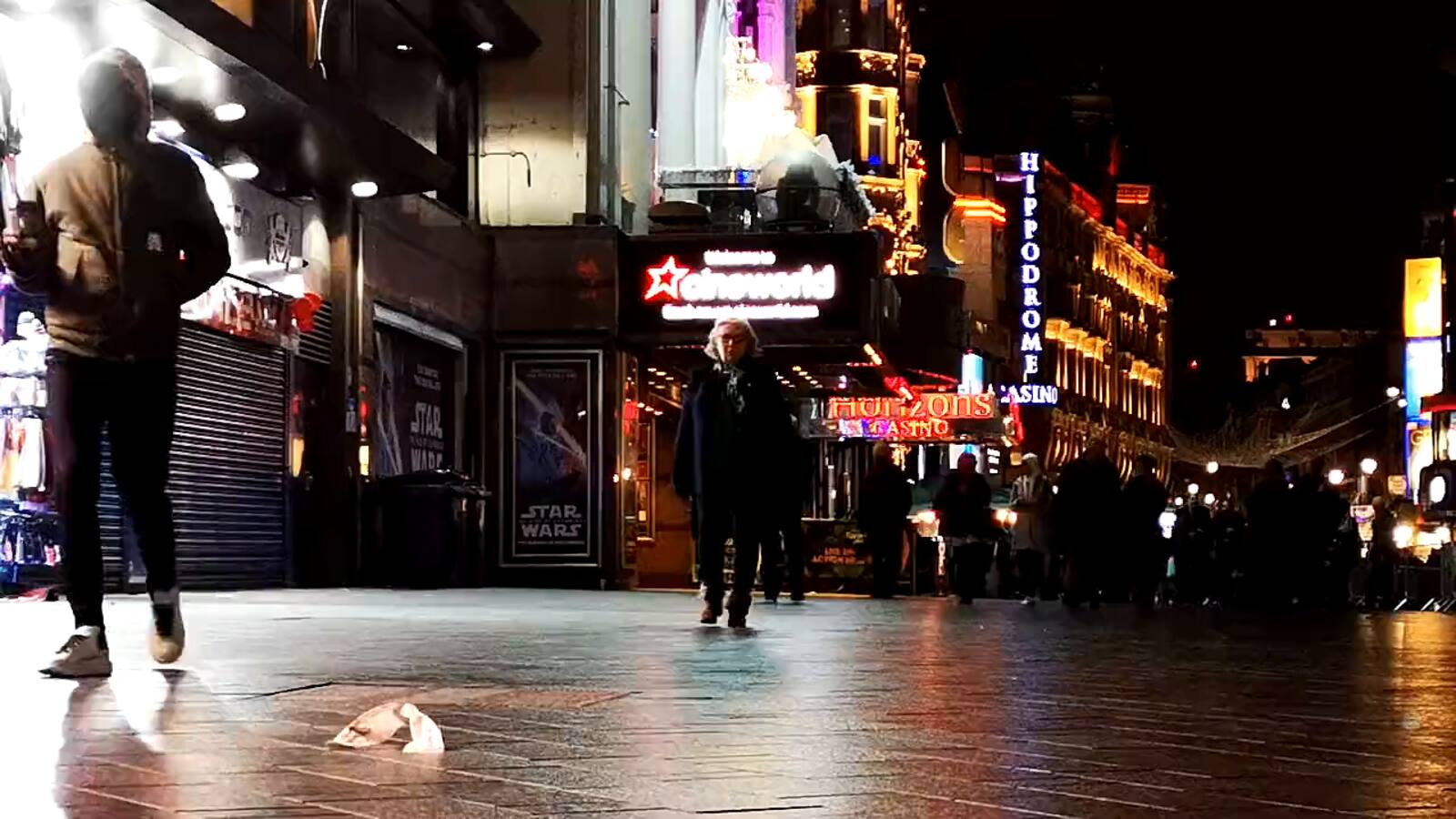 Winkelend publiek in een verlichte winkelstraat bij avond